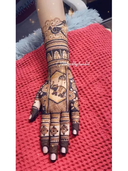 A close-up of one hand, showing the detail of the elephant in a palanquin, a classic bridal motif.