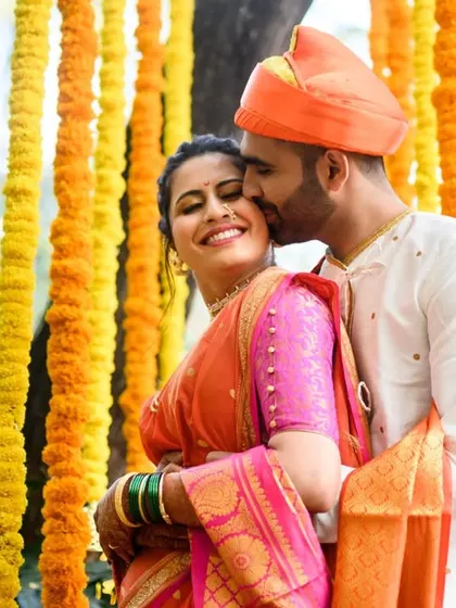 A sweet kiss on the cheek. This photo of Shamika and Sumedh is full of warmth and affection, perfectly framed by the marigold decor.