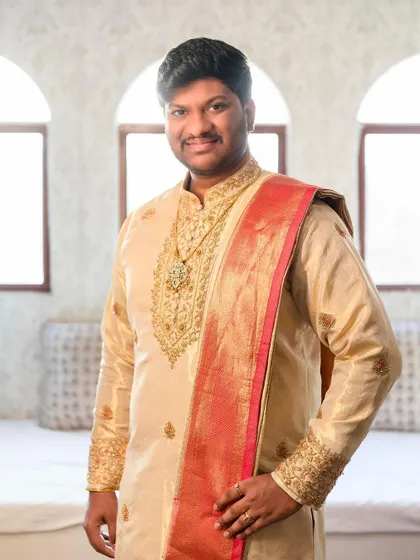 This groom looks dashing in his custom Kache Panche set. The rich gold fabric and red shawl create a look of timeless elegance.