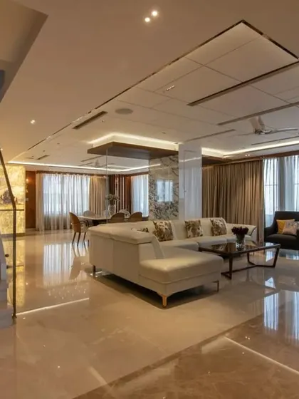 The open-plan living and dining area of the penthouse, with polished marble floors that reflect the light and create a sense of boundless space.