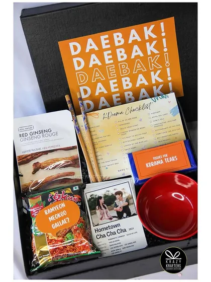 Our 'K-Drama Night' hamper, featuring a 'Daebak!' card, a K-Drama checklist, and of course, Ramyeon.