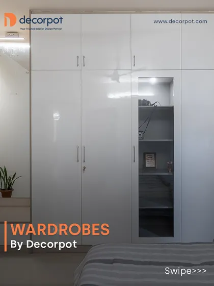 A sleek, all-white hinged wardrobe with a high-gloss finish that brightens the room. The design includes an integrated open shelving unit, perfect for displaying decor or keeping frequently used items handy.