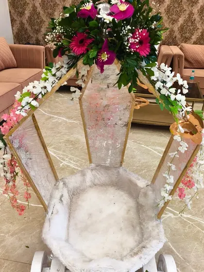 A beautifully decorated baby entry cart, adorned with fresh flowers, ready for the little princess's grand entrance at her butterfly-themed party.