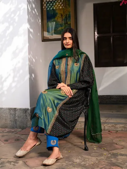 The full look of the green and black salwar kameez, styled with traditional juttis. This is a comfortable yet elegant choice for any festive occasion.