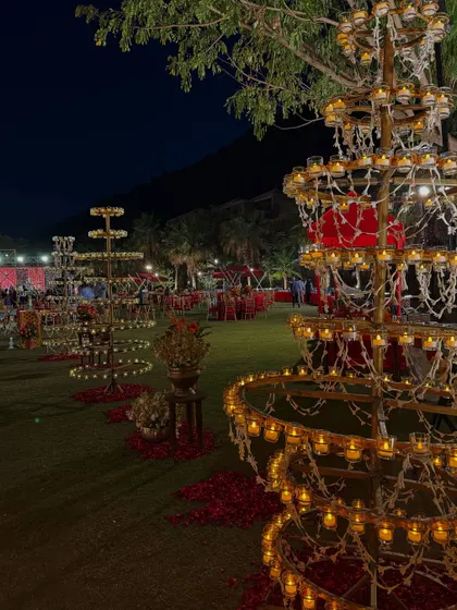 The venue at night, with multiple deepamalas creating a magical, twinkling landscape against the dark hills.