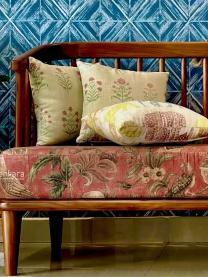 A close-up of the Sabyasachi sofa, highlighting the beautiful floral fabric and the collection of complementary throw pillows.