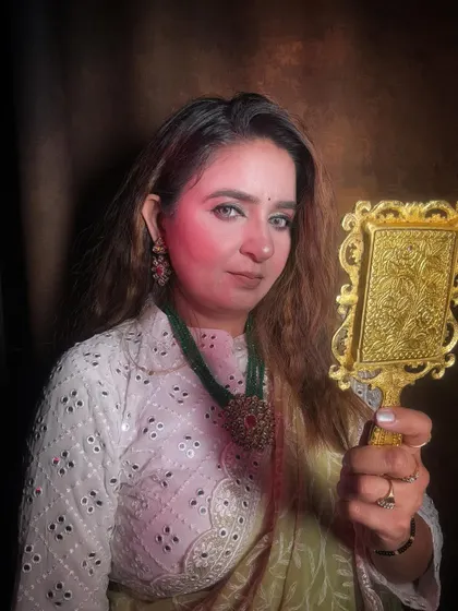 A regal and confident pose with a hand-held mirror, showing off the complete traditional look.
