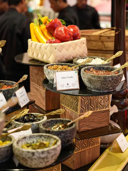 A colourful salsa and dip bar, featuring a variety of freshly made options like salsa verde and corn salsa, served in stone molcajetes. This interactive station allows guests to customize their appetizers.