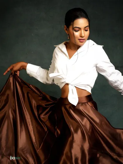 This shot is about creating shape and flow. The combination of a crisp white shirt and a flowing satin skirt, captured in motion, results in a dynamic and elegant fashion portrait.