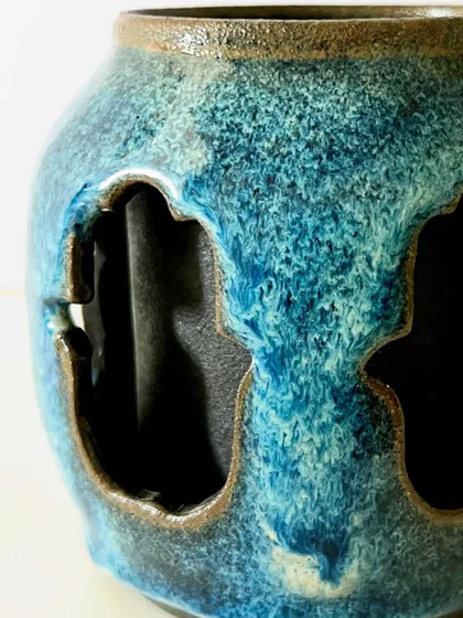 A close-up of the textured blue glaze on the double-walled Hamsa mug.