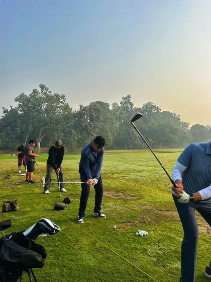 Golfers practicing their drives on the open range, with golf bags and balls ready for action.