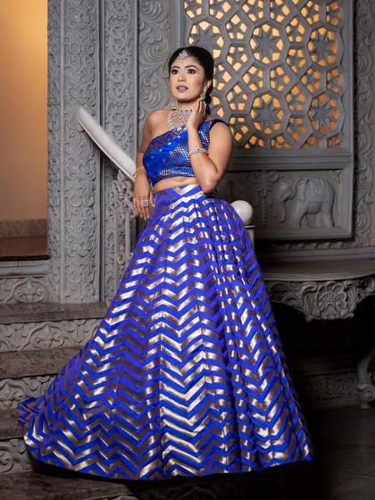 An identical shot to 101, showcasing the full, regal look of the blue and gold lehenga.