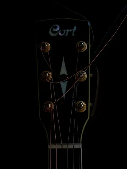 The headstock of my Cort guitar during a string change. It's a bit of a messy process, but worth it for the sound.