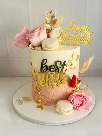 A beautiful "Best Mom Ever" cake with an ombre pink design, lace stenciling, and floral accents.