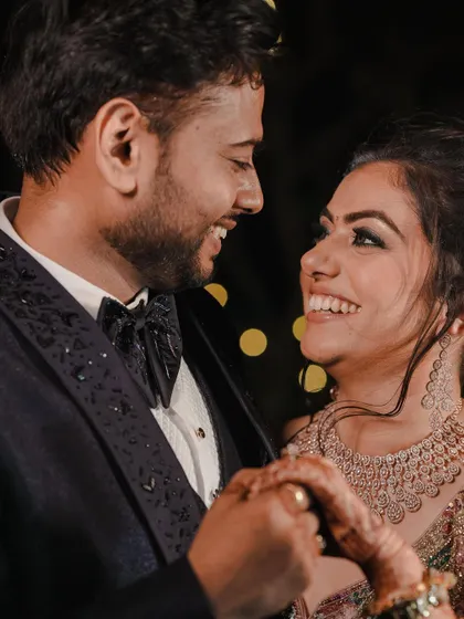 A candid close-up of the couple sharing a laugh on their engagement night. The bokeh from the background lights adds a magical touch.