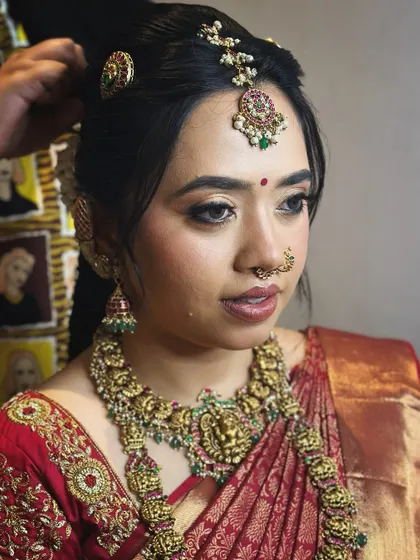 A candid moment of the bride, her makeup looking fresh and her expression joyful.