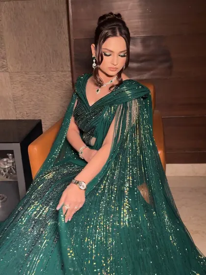 The full effect of a Hollywood-inspired glam look. The flowing, emerald green gown paired with soft, glowing makeup and an elegant updo creates a look of pure sophistication for any major event.
