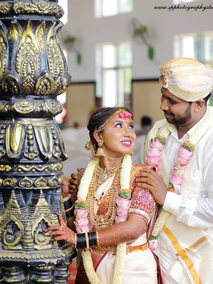 A classic wedding portrait of the couple in their traditional South Indian attire. We use the architectural elements of the venue to frame the shot beautifully.