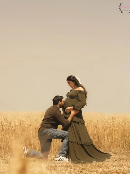 A classic maternity pose with Hasan Sartaj kissing Shireen's baby bump, a timeless expression of love and anticipation.