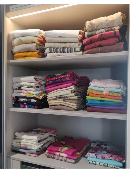 More stacks of neatly folded clothes from the same walk-in closet project. Grouping by type and color makes a huge difference.