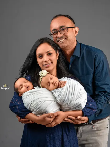 Welcoming two little bundles of joy is a special blessing. This newborn family portrait with twins showcases the tenderness and happiness of the new parents, with both babies peacefully swaddled.