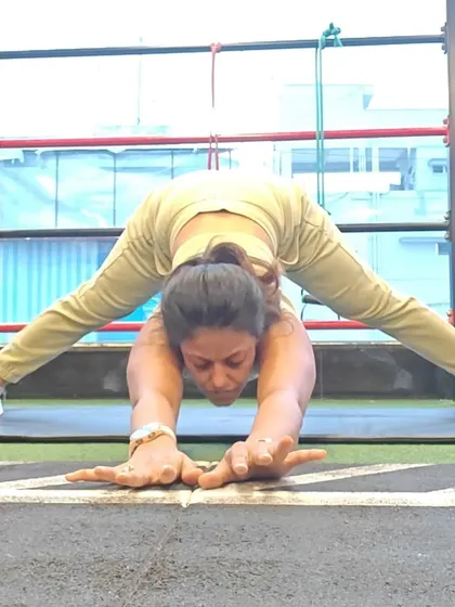 Another angle of a wide-legged forward fold, this time reaching forward to lengthen the spine. This variation adds an upper back and shoulder stretch to the hamstring and hip opening.