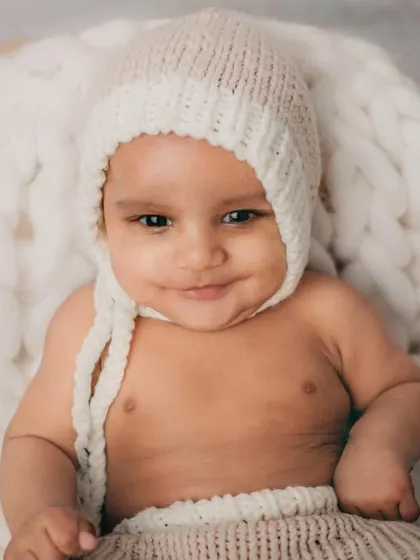 A happy, smiling baby is the best thing in the world. This little guy clearly enjoyed his cozy and warm photoshoot.
