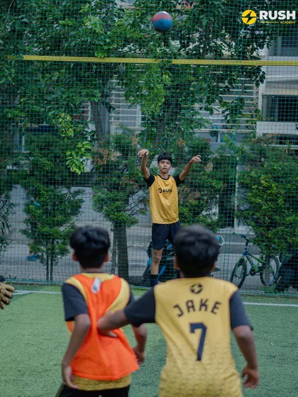 A young player jumps to head the ball during a practice session.
