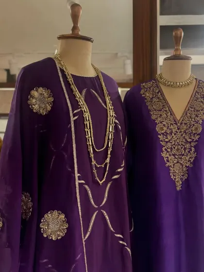 A display of regal purple kaftans, each featuring unique gold embroidery, from floral motifs to geometric patterns.