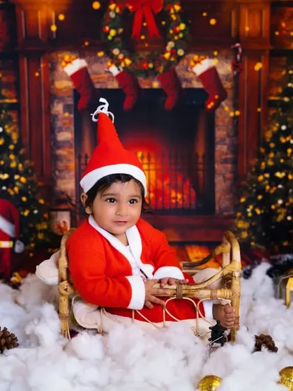 The cutest little Santa's helper. This baby boy in his Santa suit looks so sweet and festive in this cozy Christmas-themed setup.