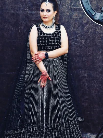 A modern black lehenga featuring a checkered pattern blouse and a striped sequin skirt. This rental is for someone who loves bold, graphic patterns.