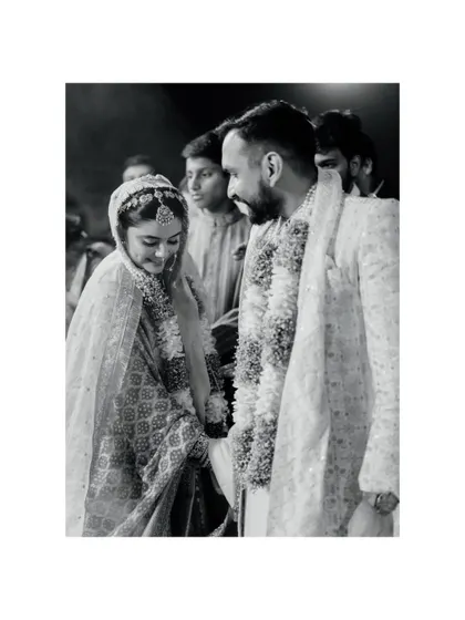 A beautiful black and white candid of the couple sharing a sweet, smiling glance during their wedding ceremony. It's a simple, yet powerful, image of their connection.