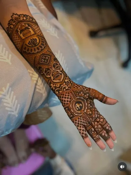 This design showcases a variety of traditional elements, including a kalash, lotus, and elephant, all woven together with intricate check and floral patterns.