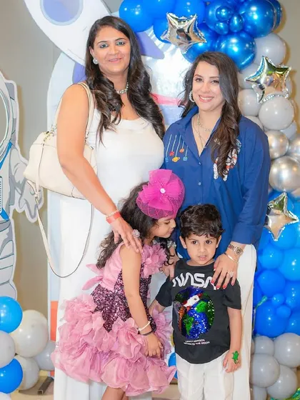 Family photo from a space-themed birthday party, with everyone dressed to match the cosmic decor.