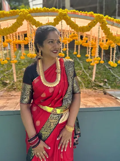 One of our best women, Pallavi, looking gorgeous and elegant in a classic red and black Kanjeevaram saree at a wedding.
