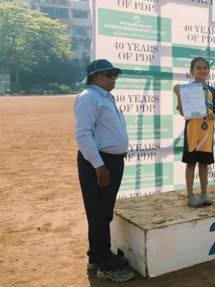 A young winner stands proudly on the podium after receiving her medal and certificate at the PDP Athletics Championships. These moments are what make all the hard work worthwhile.