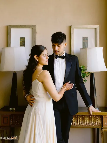 A classic, romantic portrait of the couple, her in a simple white dress and him in a tuxedo, exuding timeless elegance.