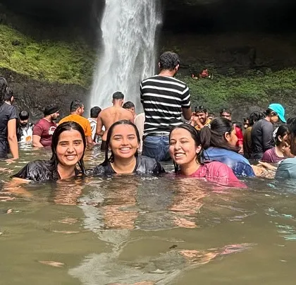 Three friends having a great time in the cool waters of Devkund Waterfall.