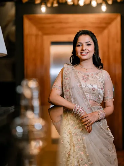 Minu looking radiant for her engagement. Her pastel lehenga is paired with soft, romantic makeup and loose curls.