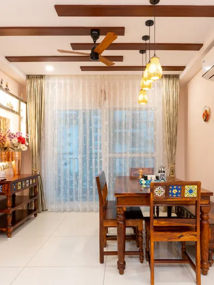 This dining area has a rustic charm, with wooden beams on the ceiling and traditional Indian-style furniture. The design creates a warm and earthy atmosphere.