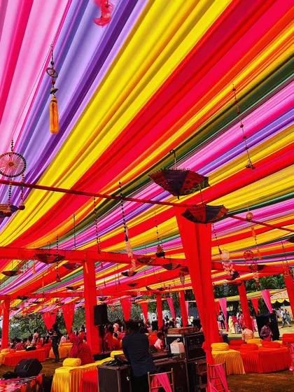A canopy of rainbow-colored drapes with hanging dreamcatchers and umbrellas, creating a vibrant and festive ceiling.