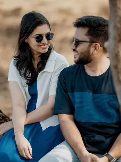 A sweet, candid moment between a couple during their outdoor pre-wedding shoot, sharing a smile and a conversation.