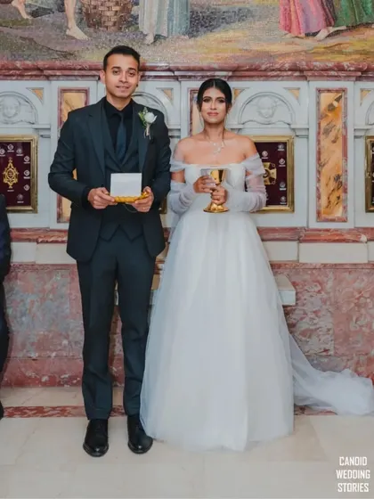 The bride and groom holding sacred items during their Catholic wedding ceremony, participating in the traditional rituals.