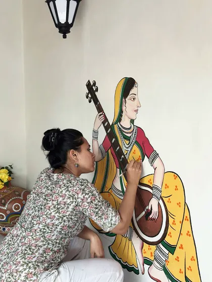I love getting lost in the details of traditional Indian art. This is a close-up of me painting a musician figure, inspired by the delicate lines of Pichwai and Madhubani styles, for a resort wall in the Konkan region.