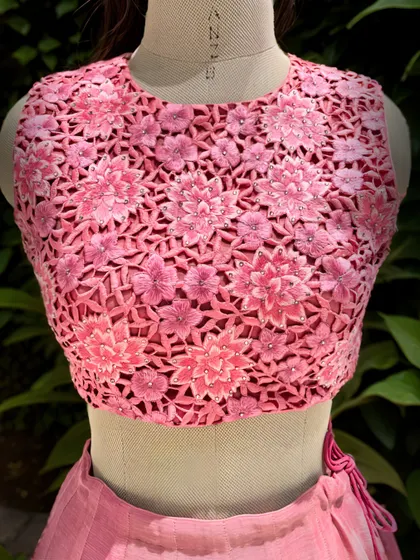 Artistry unveiled. A close-up of the exquisite cutwork embroidery on the blouse of this mesmerizing pink lehenga, perfect for a cocktail party or sangeet.