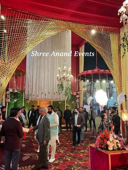 A view from inside the entrance, showing guests arriving and mingling under the grand arched structure with beautiful lighting.