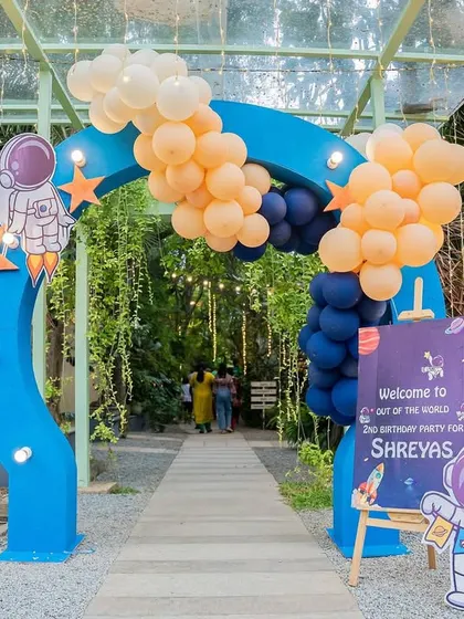 The grand entrance to an "out of this world" birthday party. A blue arch decorated with balloons and an astronaut cutout welcomes guests to the celebration.