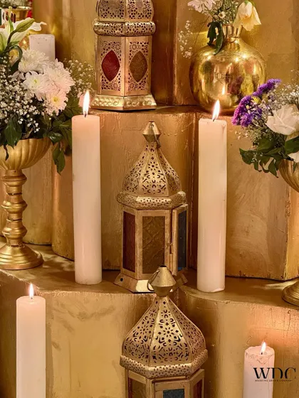 A detailed shot of the antique-style golden lanterns and pillar candles, which added a warm, romantic glow to the entire setup.