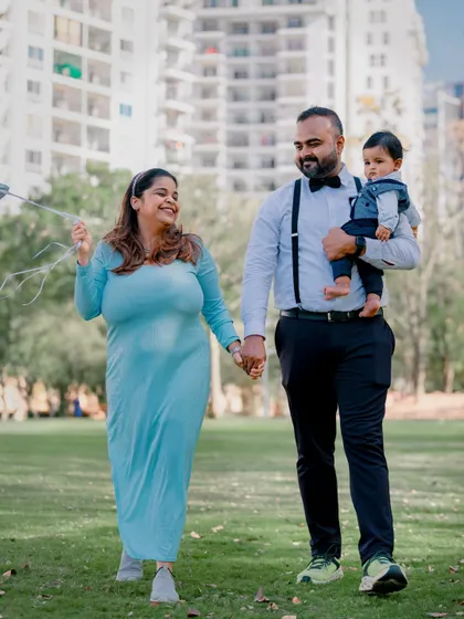 A young family taking a walk in the park. This candid, full-length shot captures the feeling of a happy day spent together.