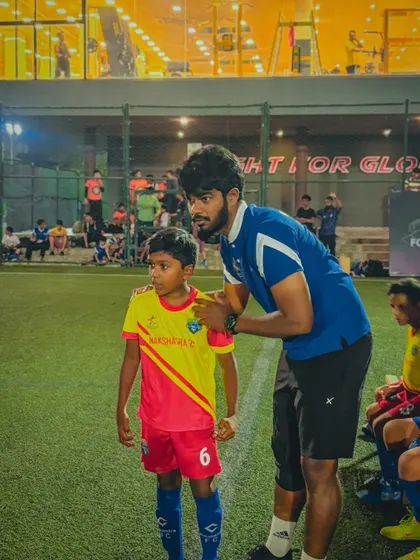 A coach offers words of encouragement to a young player on the sidelines. We believe in building confidence and taking calculated risks to create a story of success.